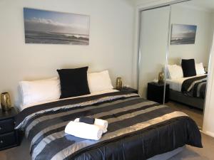 een slaapkamer met een bed met een handdoek erop bij Lbarza Stylish 3BR Central Serviced Apartment in Shepparton
