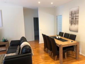 een woonkamer met een eettafel en een bank bij Lbarza Stylish 3BR Central Serviced Apartment in Shepparton