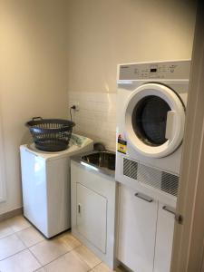 een keuken met een wasmachine en een wastafel bij Lbarza Stylish 3BR Central Serviced Apartment in Shepparton
