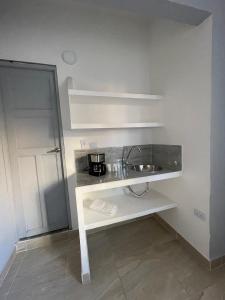 Una cocina blanca con fregadero y encimera. en Casa La 35, en Medellín