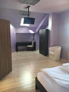 a bedroom with purple walls and a bed and a desk at The Old House in Oryakhovo
