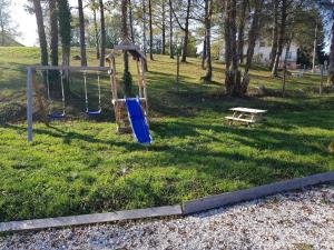 a playground with a slide and a bench in a field at Chalet chaleureux - Cerf in Maisod
