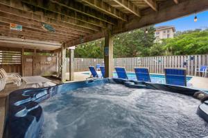 a swimming pool with blue chairs in a backyard at 2000 - Pipers Paradise in Duck