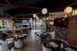 a restaurant with tables and chairs and a bar at Espectacular Apartaestudio con Piscina sobre la calle 100 in Bogotá