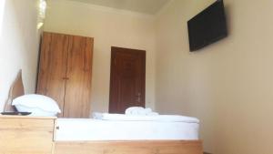 a room with a bed with a television and a door at Naqshband Terrace in Bukhara