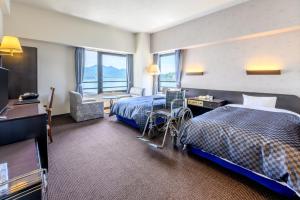 Postel nebo postele na pokoji v ubytování Miyajima Coral Hotel