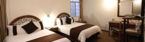 Postel nebo postele na pokoji v ubytování Hotel Argento Zacatecas