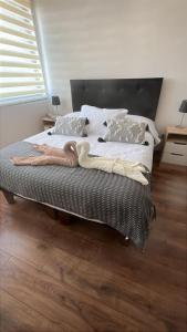 - une chambre avec un lit doté de couvertures et d'oreillers dans l'établissement Soñado depto con vista al lago, los volcanes y a todo Llanquihue, à Llanquihue