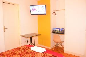 a room with a bed and a table and a tv at Hotel Santa Barbara ilo in Ilo