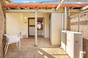 a patio with two chairs and a table and a heater at 11 Cottesloe - steps from beach - sleeps 3 in Perth