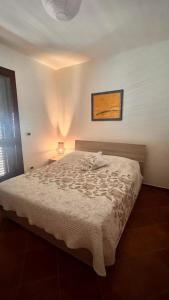 a bedroom with a bed with a white comforter at Dimora Lucci Marini in Taranto +3 photos