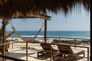 Eine Hängematte und Stühle an einem Strand mit dem Meer in der Unterkunft UtopiAmar Beach House & Suites in Playa Agua Blanca + 20 Fotos