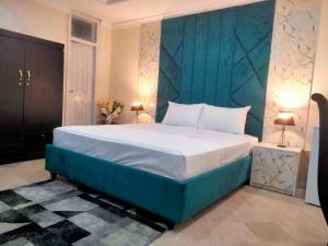 Un dormitorio con una cama grande con cabecero azul. en Dazzy Dream Guest Houses, en Islamabad 14 fotos más