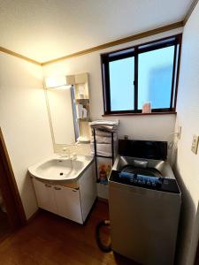 仙台市にあるSendai Riverside Retreatの洗面台と洗濯機を備えた小さなバスルーム
