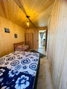 a bedroom with a bed in a room with wooden walls at ორსაძინებლიანი კოტეჯი 