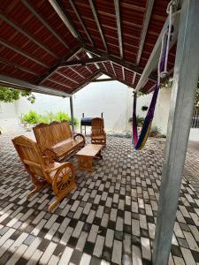 a porch with two wooden chairs and a swing at Casa en La Trinidad in La Unión +18 photos