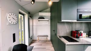 a small kitchen with a clock on the wall at Piekrastes 20 River View House in Jūrmala
