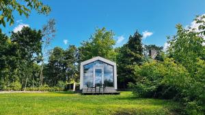 a small glass house in a field of grass at Piekrastes 20 River View House in Jūrmala