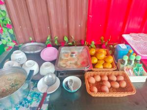 a table with baskets of eggs and fruit on it at อามา ภูลังกา เฮาส์ in Ban Sakoen +33 photos
