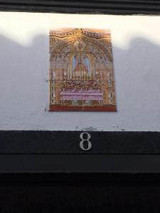 a sign on the side of a building with the number eight at Santo Cristo House in Ponta Delgada