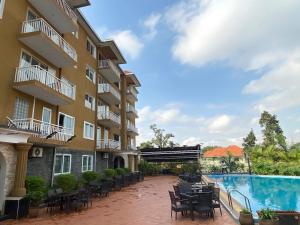 a hotel with a swimming pool and tables and chairs at Hotel Duomo and Suites in Kampala