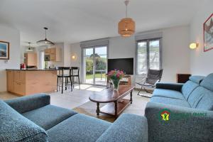 een woonkamer met twee blauwe banken en een tafel bij La vigerie in Carnac