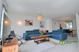 een woonkamer met twee blauwe banken en een tafel bij La vigerie in Carnac