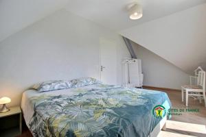 een slaapkamer met een bed met een kleurrijke sprei bij La vigerie in Carnac