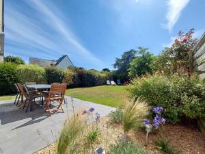 een patio met een tafel en stoelen in een tuin bij La vigerie in Carnac