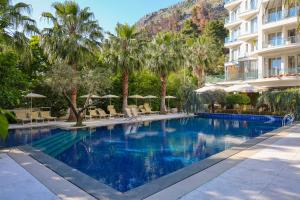 a swimming pool with palm trees and a hotel at Hotel Mille Amici in Shëngjin