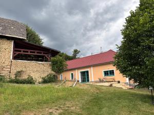 een huis met een rood dak en een gebouw bij Sad u Harušťákov in Lubina