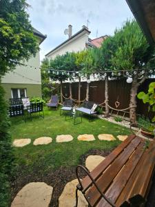 a yard with a bench and chairs and a fence at Penzión Tiberia in Trenčín