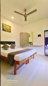 a large bed in a room with a ceiling fan at Mishita Resort couple friendly with pool near beach in Alibaug