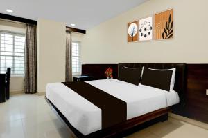 a bedroom with a large bed in a room at Super Townhouse Oak Anu Hospital Elur Road Formerly Grand Tankasala in Gunadala