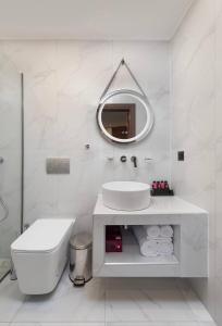 a white bathroom with a sink and a mirror at Evdokia Artheon in Rhodes Town