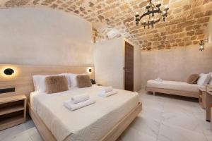a bedroom with a large bed with towels on it at Evdokia Artheon in Rhodes Town +28 photos