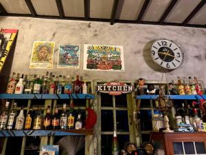 a bar with lots of bottles and a clock on the wall at Latehouse bar Amphawa in Amphawa