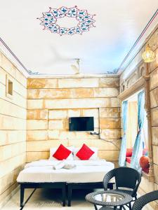 Hotel Amazing Jaisalmer في جيلسامر: غرفة نوم بسرير ومخدات حمراء