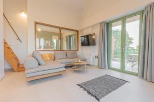 a living room with a couch and a table at Alkyoni luxury apartments Katakolo in Katakolon