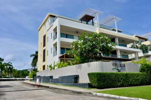 a white building with a fence in front of it at The Pelican Suite Residence Condo Klong Muang, Krabi in Klong Muang Beach