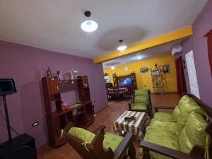 a living room with a couch and chairs and a tv at Casa Tomas 2 in Villa Unión