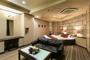 a hotel room with a bed and a couch at HOTEL ZOOM - Couple's Hotel in Beppu