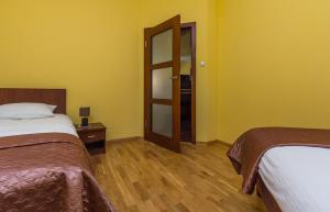 a hotel room with two beds and a door at Apartament Stare Miasto 2 in Elblag