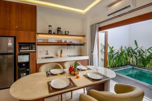 a kitchen and dining room with a table and a pool at Ellavie Villa Nusa Dua in Nusa Dua