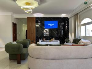Una sala de estar con un sofá y un televisor en SKY LOUNGE by BC residence, en New cairo