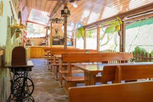 un comedor con mesas y bancos de madera en Marianas Guesthouse, en Obzor