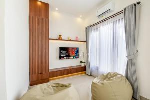 a living room with a window and a couch at Ellavie Villa Nusa Dua in Nusa Dua