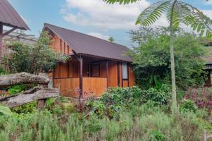 a wooden house with a garden in front of it at Kampung Bingo Glamping & Resto by Great Bali Villas in Bedugul