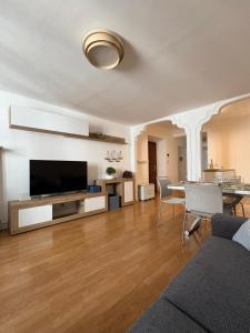a living room with a television and a table with chairs at Fanzago Home in Pisogne