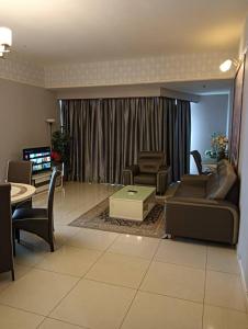 a living room with a couch and chairs and a table at My Residence Villa Times Square KL in Kuala Lumpur